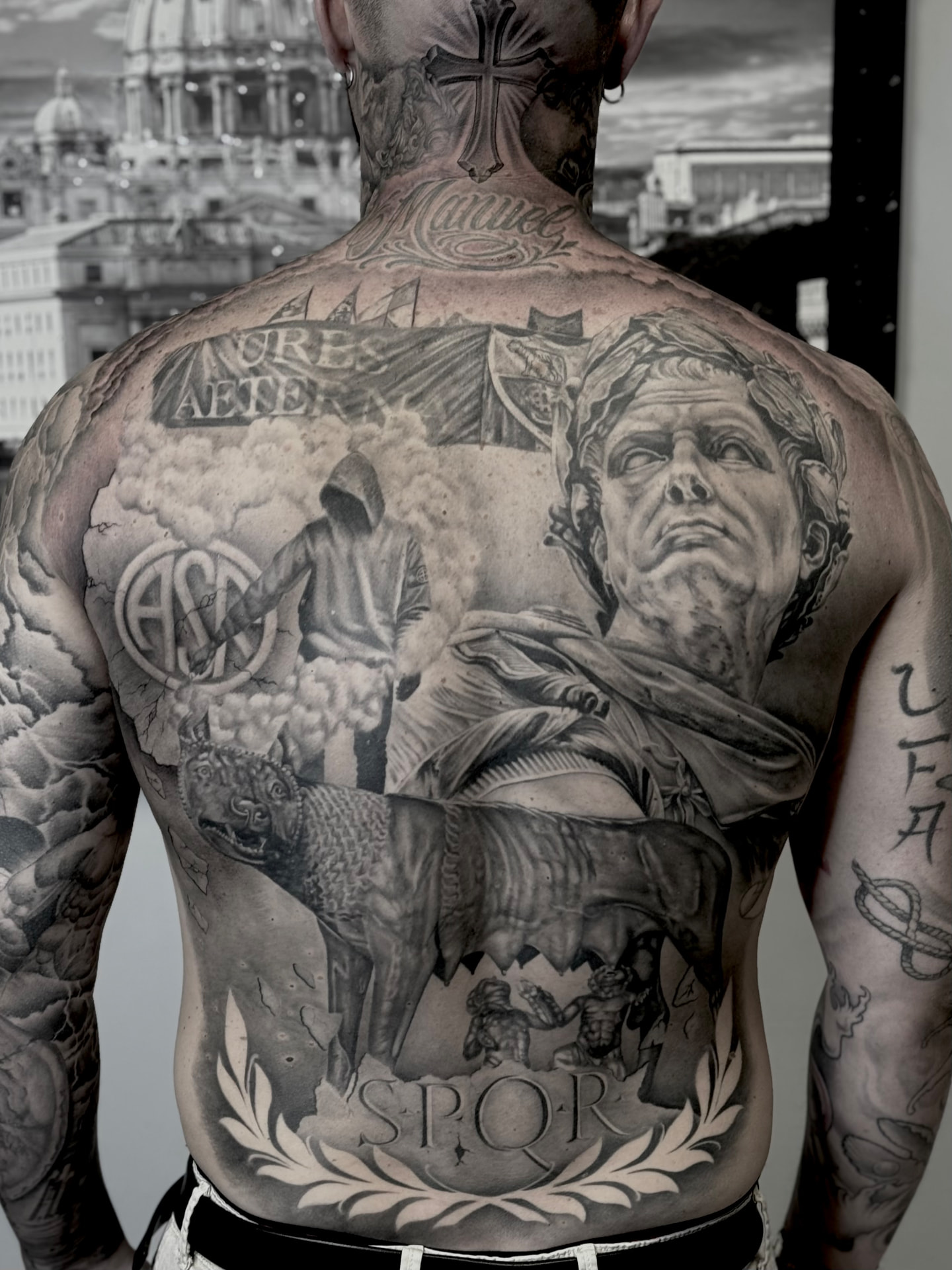 Grande tatuaggio realistico su schiena con lupa capitolina, scena classica e scritta SPQR