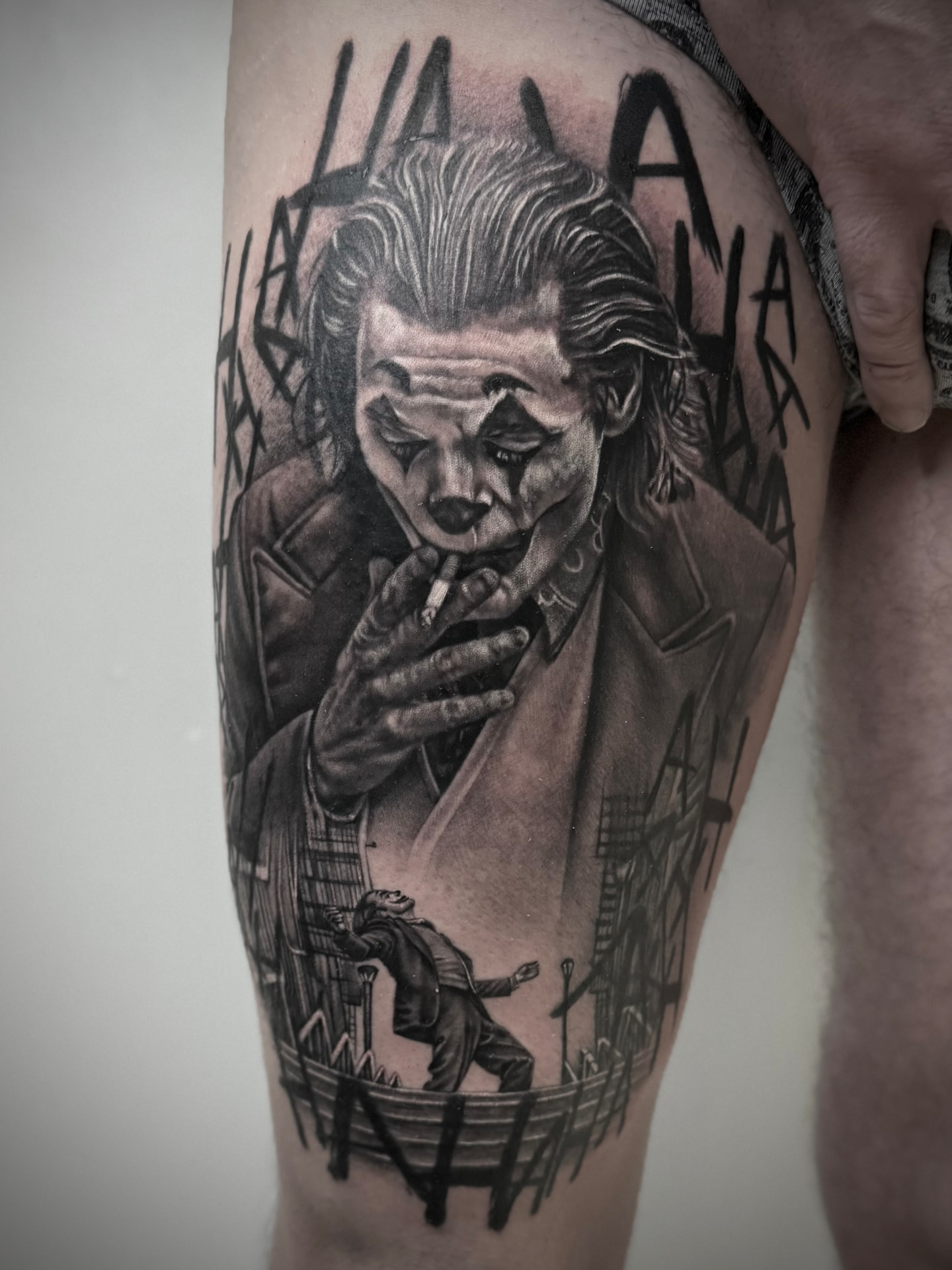 Tatuaggio realistico su gamba con ritratto e scena urbana